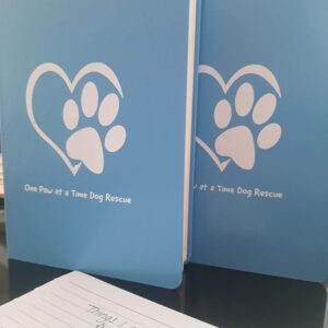 Blue paper journals with white paw and loveheart motif on the front
